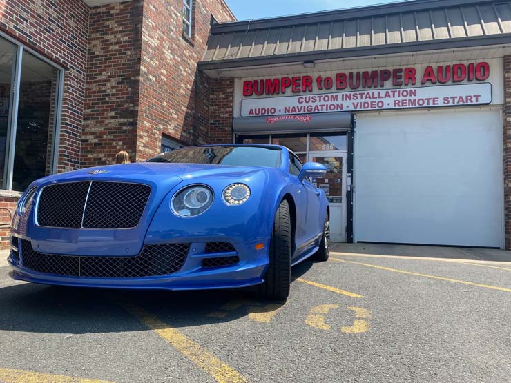 A blue sports car in front of Bumper to Bumper Car Audio
