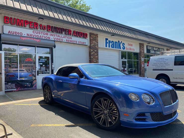 A blue sports car in front of Bumper to Bumper Car Audio